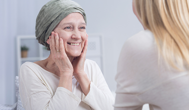 A woman wearing a headscarf is comforted by another woman in a supportive and caring environment.